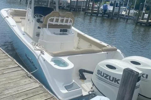 Slide: The Image of 2018 NauticStar 2602 Legacy boat docked, featuring dual Suzuki engines. - 18