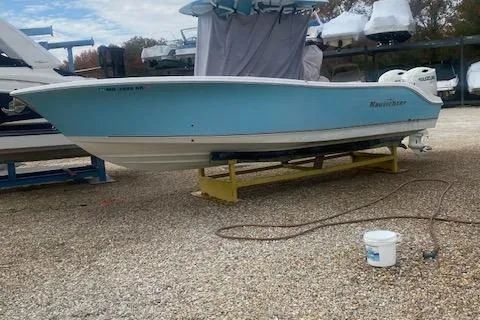 Slide: The Image of 2018 NauticStar 2602 Legacy boat on a stand, light blue hull, outdoor setting. - 19