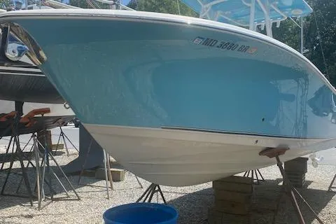 Slide: The Image of 2018 NauticStar 2602 Legacy boat on stands, blue hull, outdoor setting. - 5