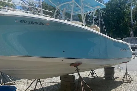 Slide: The Image of 2018 NauticStar 2602 Legacy boat on stands, light blue hull, outdoors. - 6