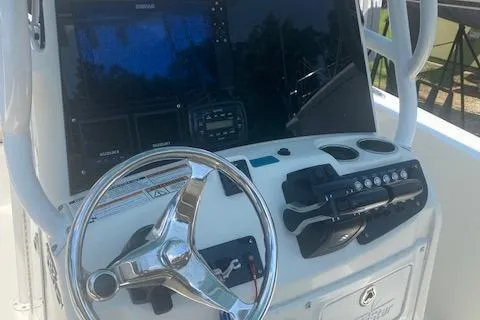 Slide: The Image of 2018 NauticStar 2602 Legacy boat dashboard with steering wheel and control panel. - 7