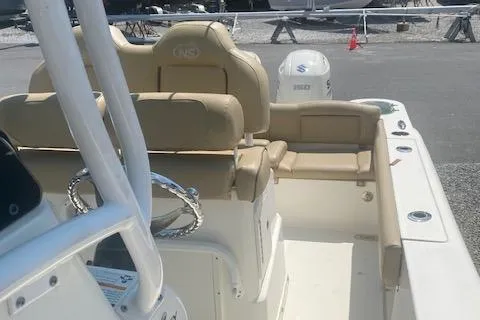 Slide: The Image of 2018 NauticStar 2602 Legacy boat interior with beige seating and steering wheel. - 8