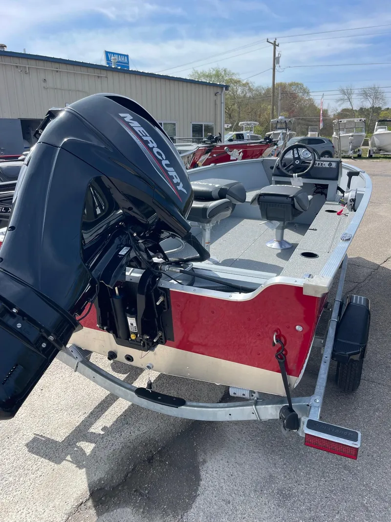 Slide: The Image of 2025 Lund 1600 Fury SS boat with Mercury outboard motor, parked outdoors. - 2