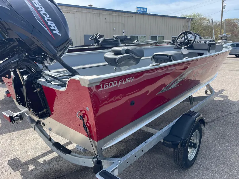 Slide: The Image of 2025 Lund 1600 Fury SS boat with Mercury engine, red exterior, on a trailer. - 3