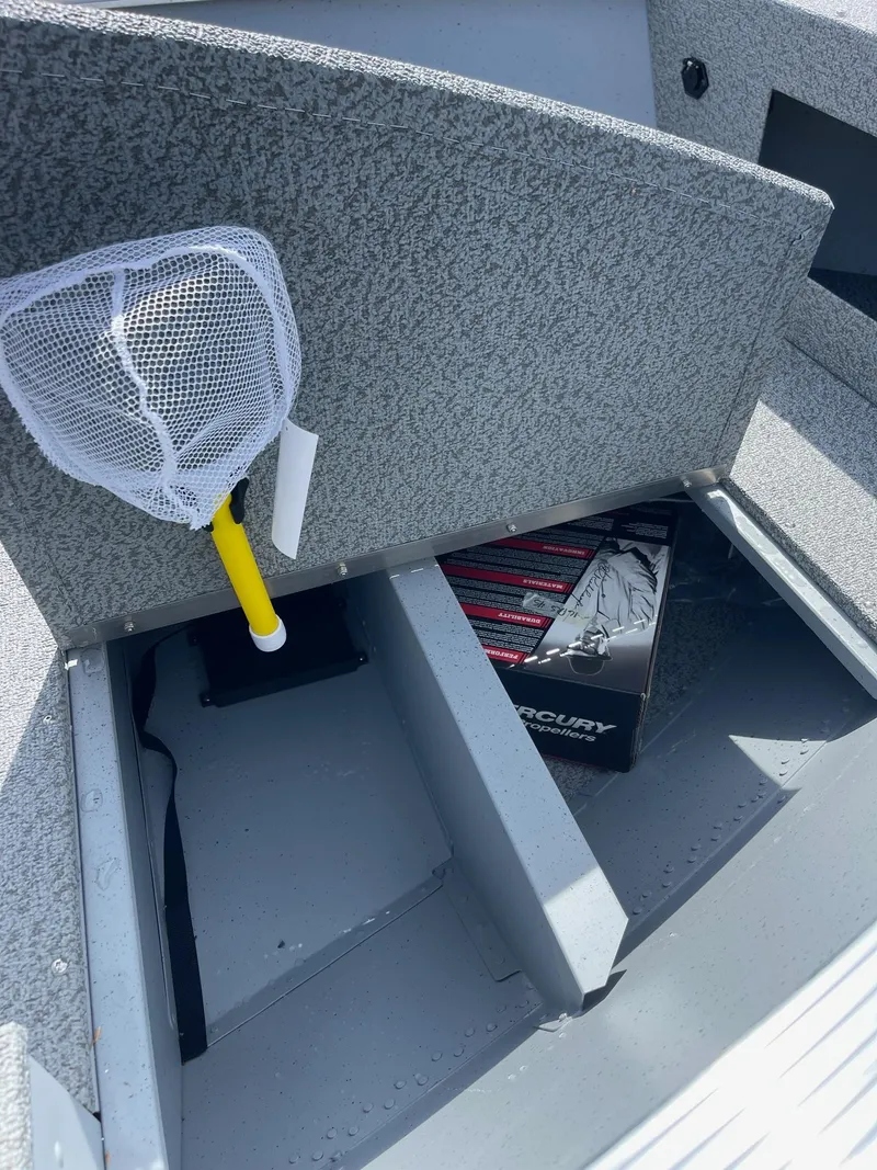 Slide: The Image of 2025 Lund 1600 Fury SS boat interior with storage compartment and fishing net. - 8