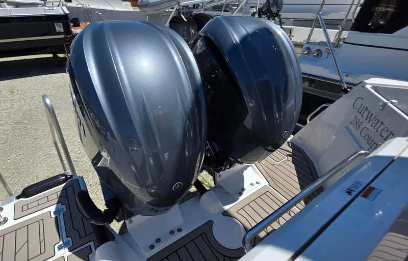 Slide: The Image of Twin outboard engines on a 2025 Cutwater C-288 Coupe boat, docked with visible deck details. - 13