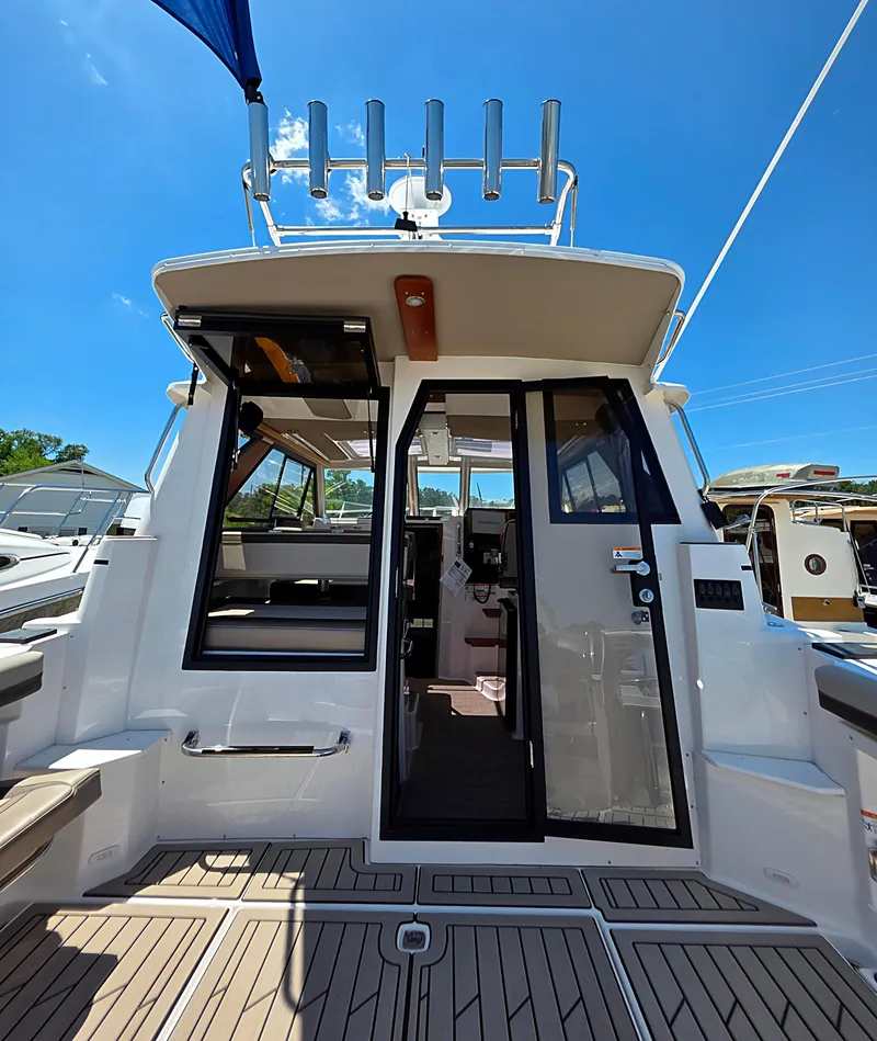 Slide: The Image of 2025 Cutwater C-288 Coupe boat with open cabin doors under clear blue sky. - 5