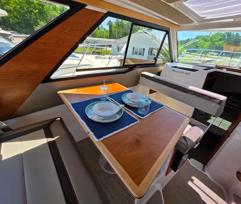 Slide: The Image of Interior of 2025 Cutwater C-288 Coupe with elegant dining setup and scenic window view. - 7