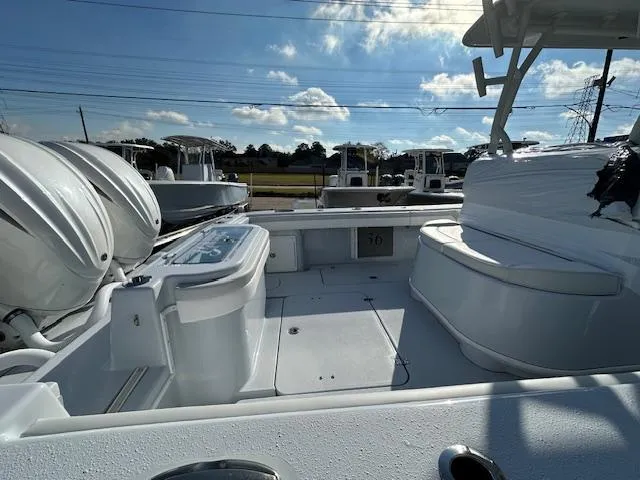 Slide: The Image of 2024 Yellowfin 36 Offshore boat interior with seating and storage, under a clear blue sky. - 11