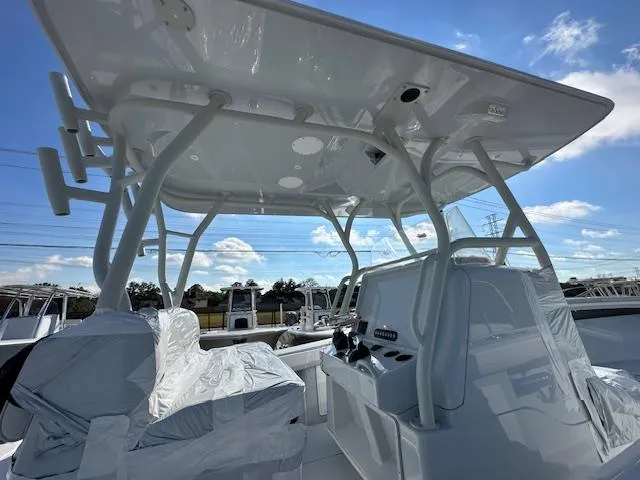 Slide: The Image of 2024 Yellowfin 36 Offshore boat interior with helm and seating under a clear blue sky. - 6