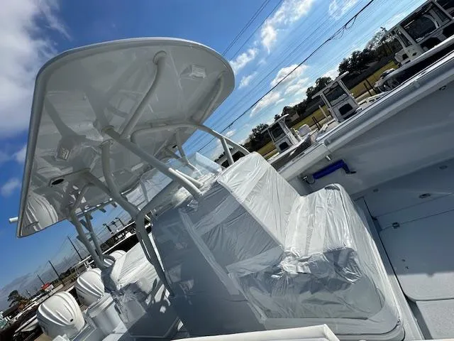 Slide: The Image of 2024 Yellowfin 36 Offshore boat with covered seating and T-top under a clear blue sky. - 7