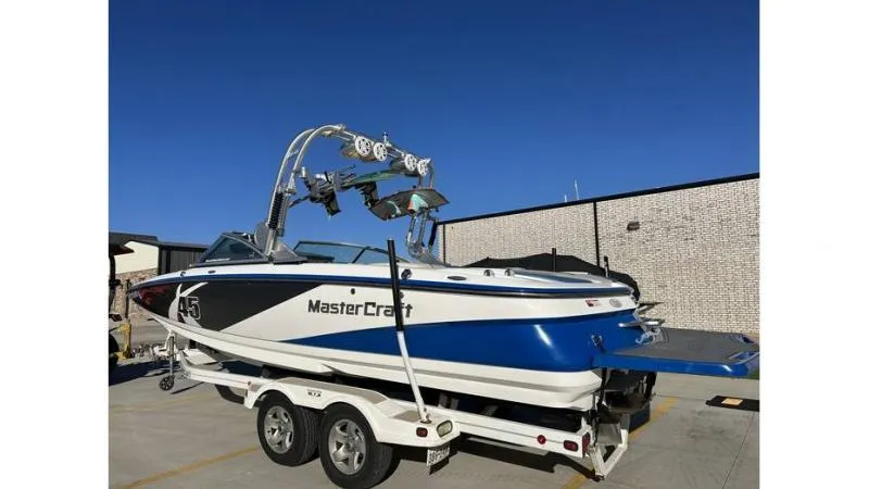 Slide: The Image of 2012 MasterCraft X45 boat on trailer, blue and white design, parked outdoors. - 8