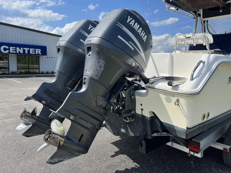 Slide: The Image of 2006 Sea Hunt Triton 260 with twin Yamaha outboard motors, parked near a center. - 10