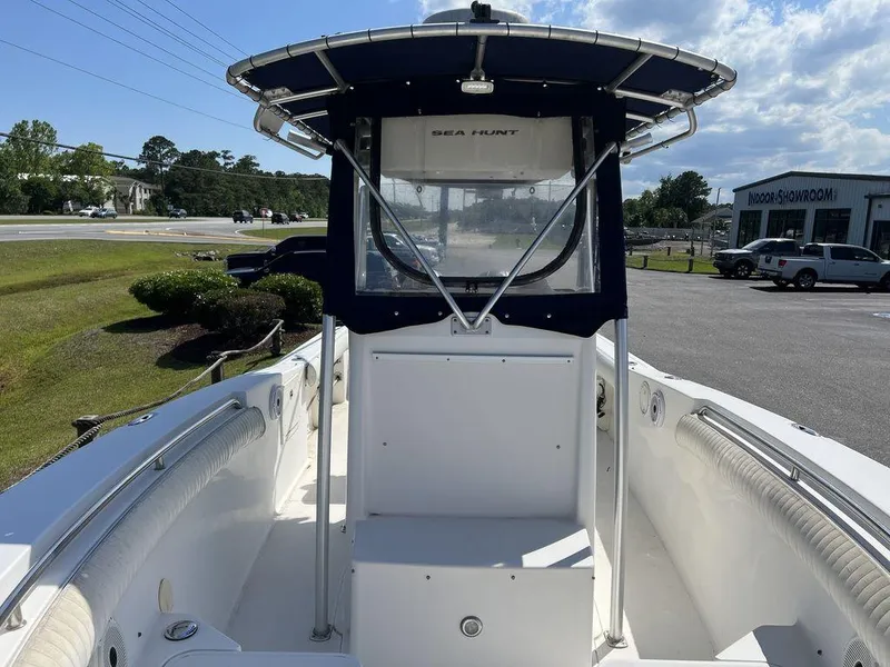 Slide: The Image of 2006 Sea Hunt Triton 260 boat with T-top, parked outdoors on a sunny day. - 12