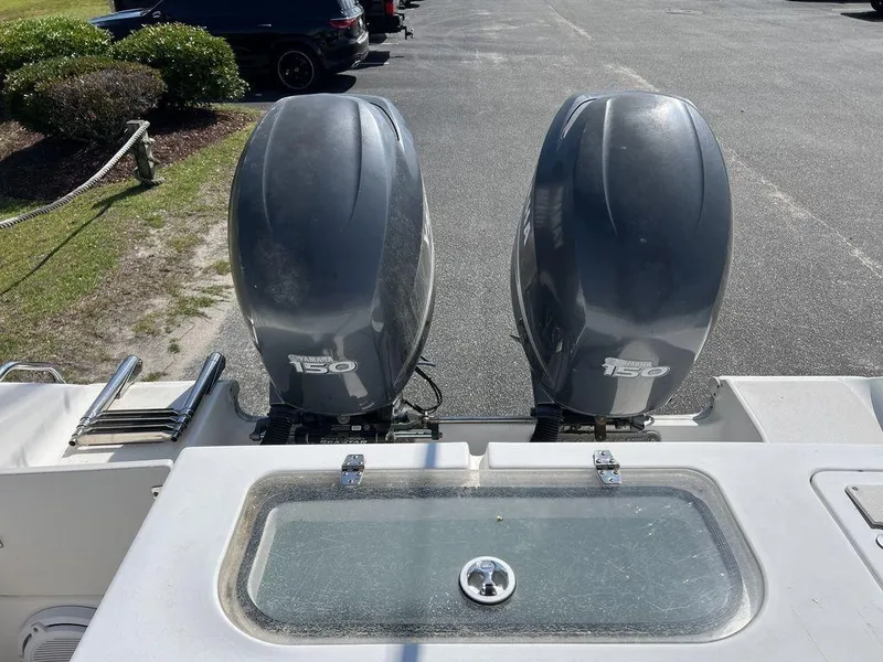 Slide: The Image of 2006 Sea Hunt Triton 260 with twin 150 horsepower outboard engines in a parking area. - 15