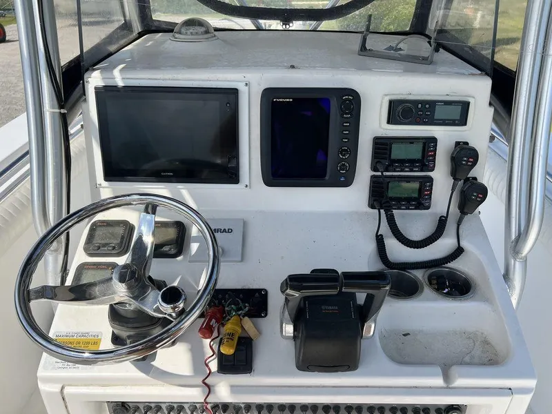 Slide: The Image of 2006 Sea Hunt Triton 260 boat dashboard with steering wheel and navigation equipment. - 16