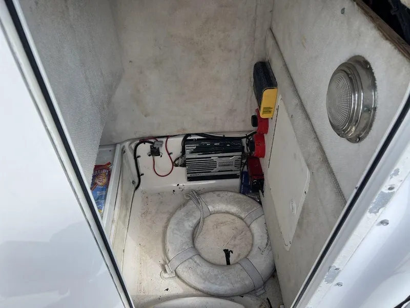 Slide: The Image of 2006 Sea Hunt Triton 260 storage compartment with life rings and equipment. - 20