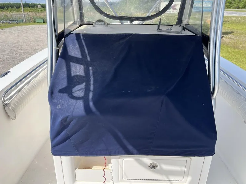 Slide: The Image of 2006 Sea Hunt Triton 260 boat console with blue cover and storage compartment. - 22