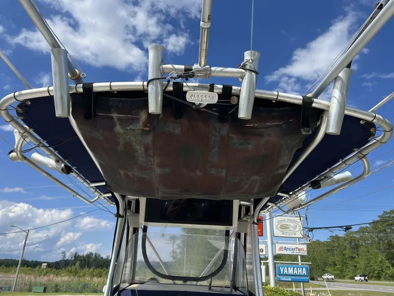 Slide: The Image of 2006 Sea Hunt Triton 260 boat with T-top, clear sky background, Yamaha sign visible. - 25