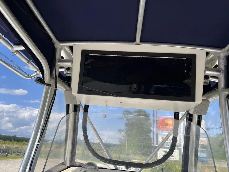 Slide: The Image of 2006 Sea Hunt Triton 260 boat console with canopy, clear skies in the background. - 26