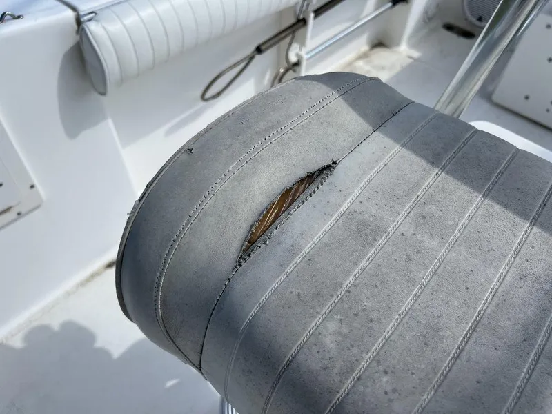 Slide: The Image of Torn seat upholstery on 2006 Sea Hunt Triton 260 boat, showing wear and damage. - 30