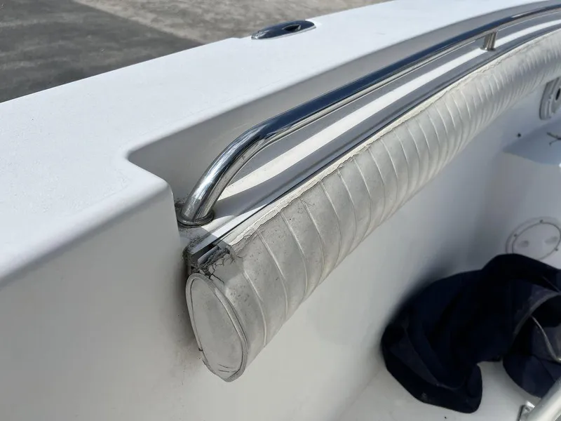 Slide: The Image of 2006 Sea Hunt Triton 260 boat interior with stainless steel railing and cushioned side panel. - 32