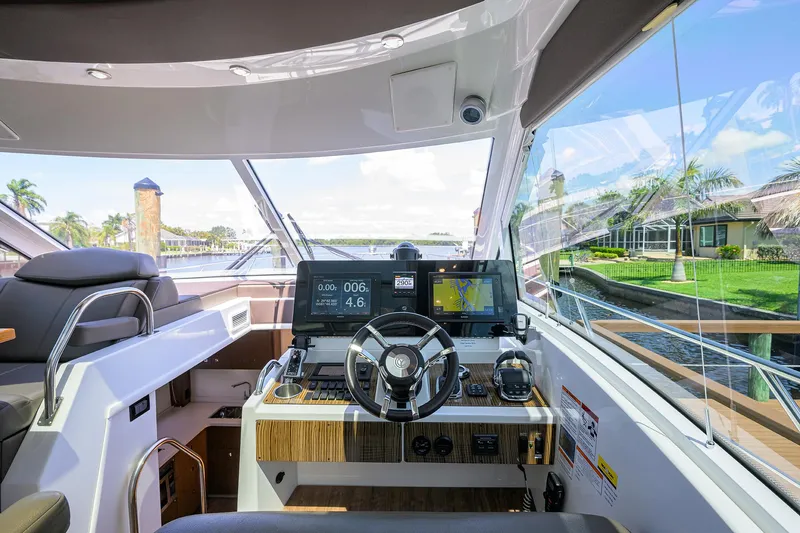 Slide: The Image of 2015 Cruisers Cantius yacht helm with modern controls and waterfront view. - 15