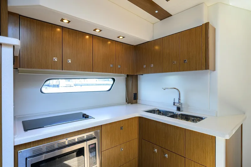 Slide: The Image of Luxurious 2015 Cruisers Cantius yacht kitchen with modern wood cabinetry and sleek appliances. - 20