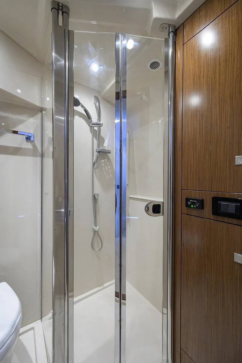 Slide: The Image of 2015 Cruisers Cantius yacht bathroom with glass shower and wooden cabinetry. - 26