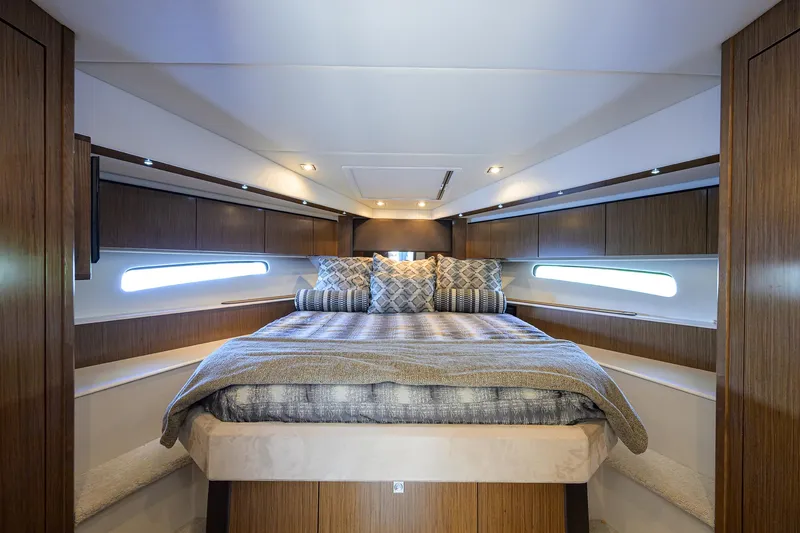 Slide: The Image of Luxurious 2015 Cruisers Cantius yacht bedroom with modern wood paneling and elegant bedding. - 27