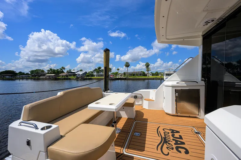 Slide: The Image of 2015 Cruisers Cantius yacht deck with seating, table, and scenic waterfront view. - 3