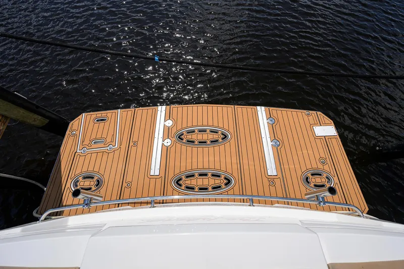 Slide: The Image of 2015 Cruisers Cantius yacht deck with wood finish, overlooking water. - 37