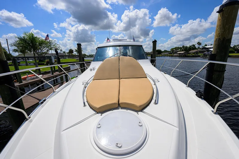 Slide: The Image of 2015 Cruisers Cantius yacht with sunpad, docked under a blue sky with clouds. - 39