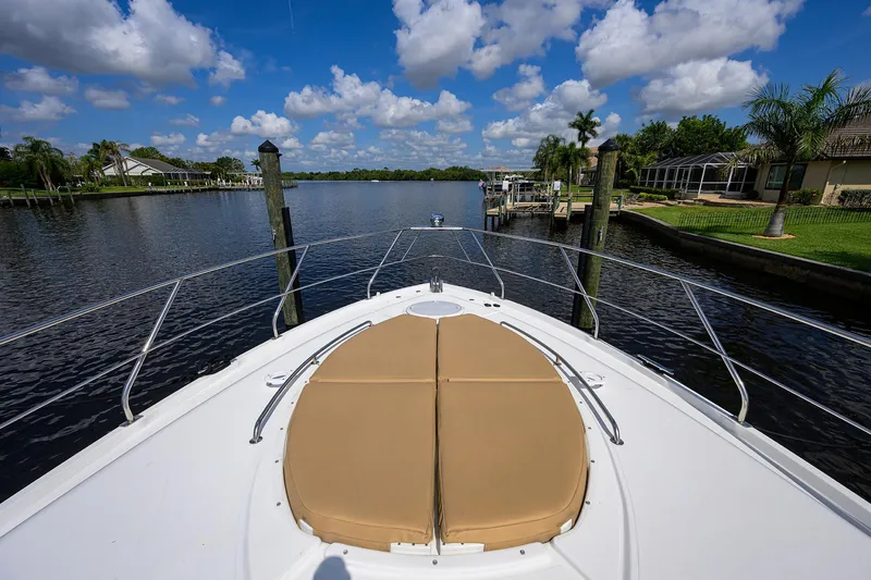 Slide: The Image of 2015 Cruisers Cantius boat bow view on a sunny day, docked by a scenic river. - 40