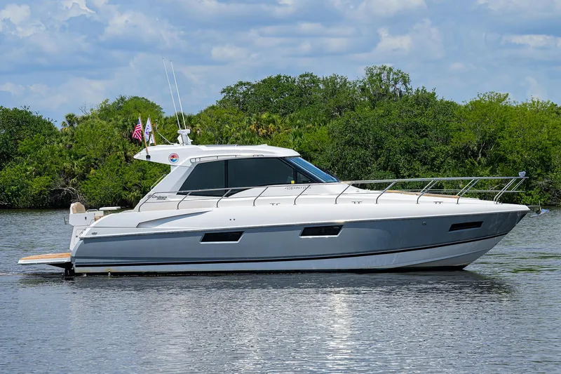 Slide: The Image of 2015 Cruisers Cantius yacht on calm water with lush greenery background. - 42