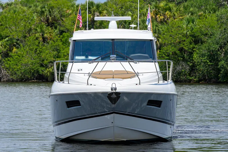 Slide: The Image of 2015 Cruisers Cantius yacht on calm water, lush greenery in background. - 43