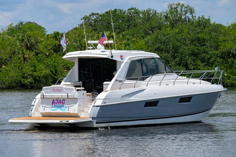 Slide: The Image of 2015 Cruisers Cantius yacht on a serene waterway, surrounded by lush greenery. - 45