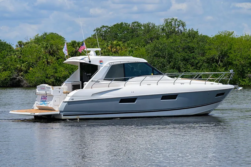 Slide: The Image of 2015 Cruisers Cantius yacht on a serene river with lush greenery. - 46