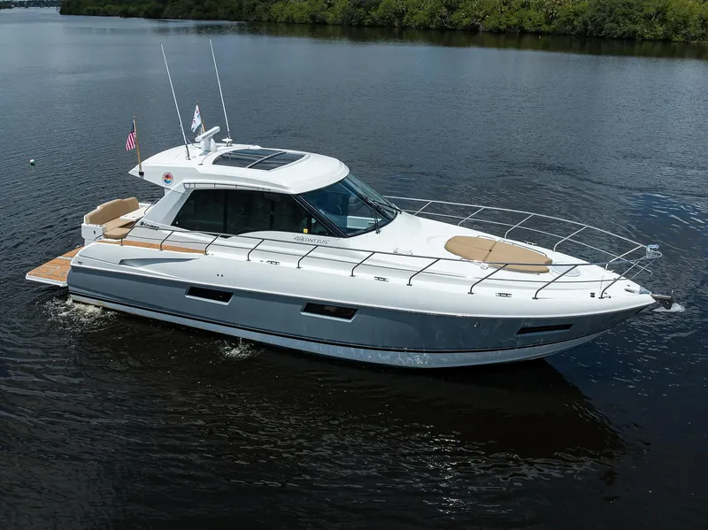 Slide: The Image of 2015 Cruisers Cantius yacht cruising on calm water, featuring sleek design and spacious deck. - 48