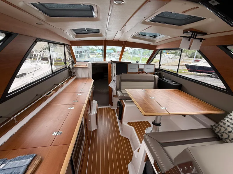 Slide: The Image of 2025 Cutwater C-32 C interior with wood accents and spacious seating. - 10
