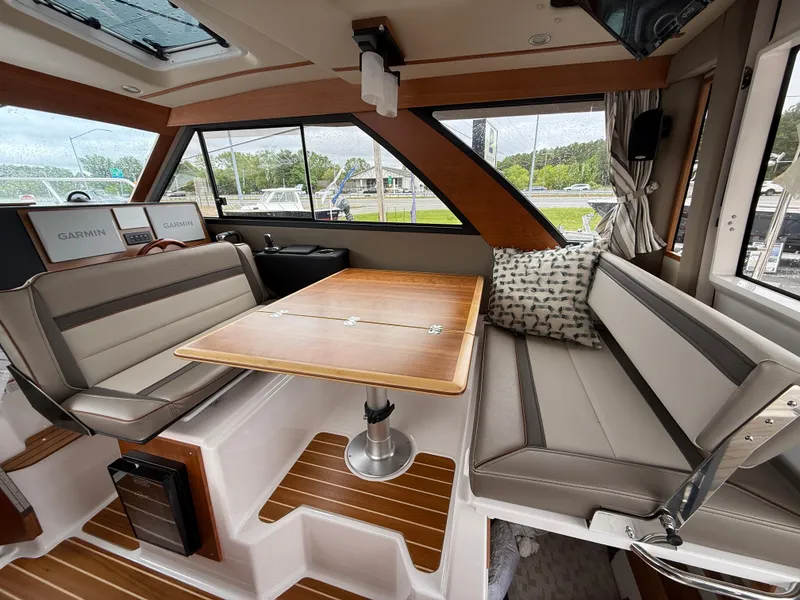 Slide: The Image of 2025 Cutwater C-32 C interior with seating, table, and large windows. - 11