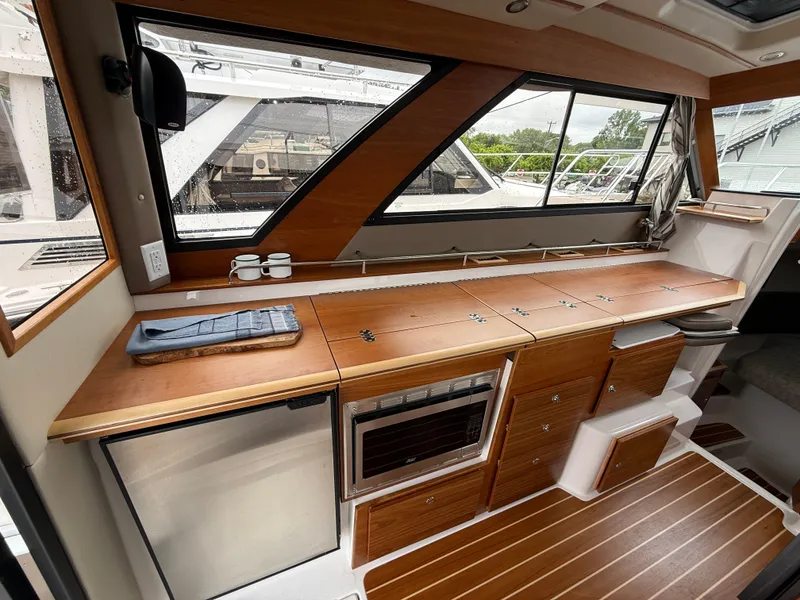 Slide: The Image of Interior of 2025 Cutwater C-32 C boat with wooden cabinetry and modern appliances. - 12