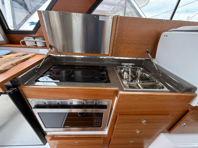 Slide: The Image of Modern kitchen in 2025 Cutwater C-32 C boat with stove, sink, and oven. - 14