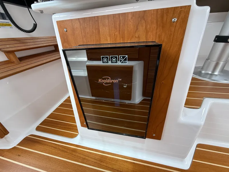 Slide: The Image of 2025 Cutwater C-32 C interior with wood paneling and compact refrigerator. - 15