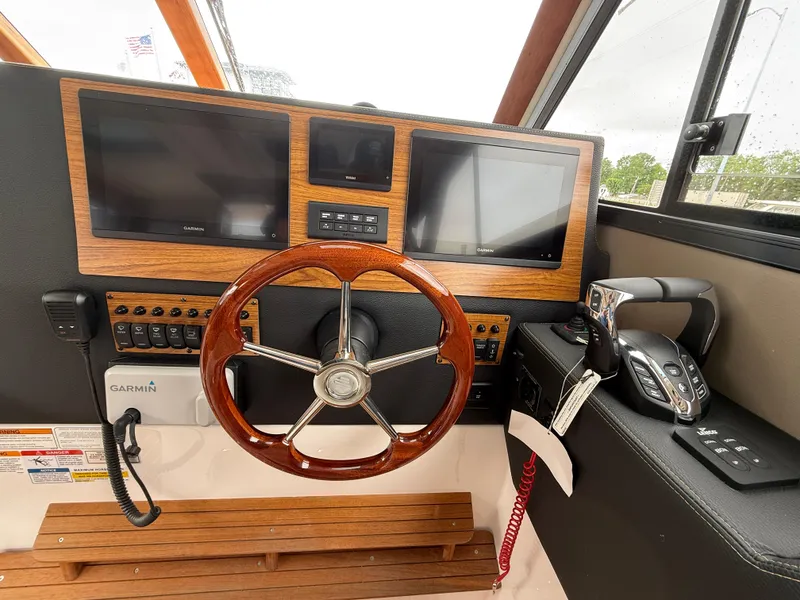 Slide: The Image of Helm of 2025 Cutwater C-32 C with dual screens and wooden steering wheel. - 17