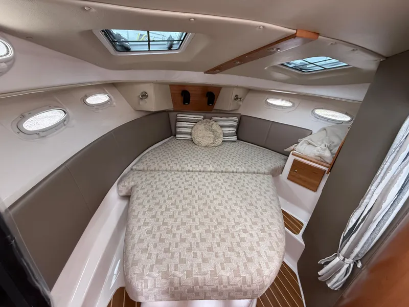 Slide: The Image of 2025 Cutwater C-32 C cabin interior with cozy bed and skylights. - 18