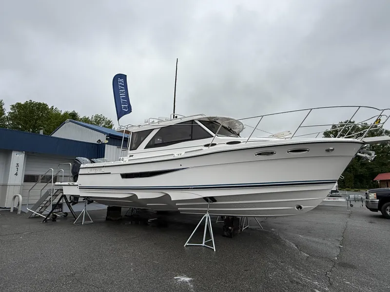 Slide: The Image of 2025 Cutwater C-32 C boat displayed on stands in a marina setting. - 2
