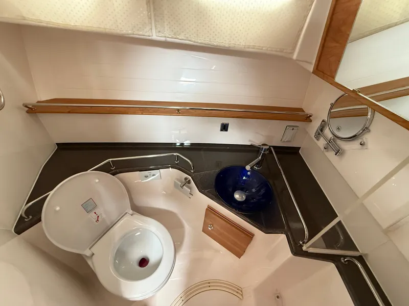 Slide: The Image of Compact bathroom in 2025 Cutwater C-32 C boat with toilet and blue sink. - 21