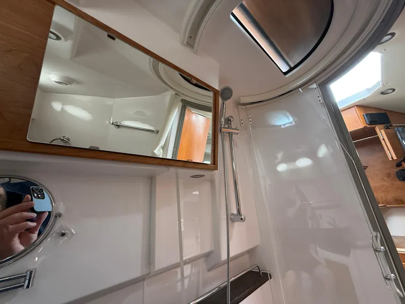Slide: The Image of Bathroom interior of 2025 Cutwater C-32 C boat, featuring mirrors and shower fixtures. - 22