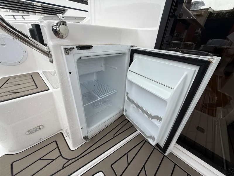 Slide: The Image of Open refrigerator on 2025 Cutwater C-32 C boat, showcasing interior storage space. - 9